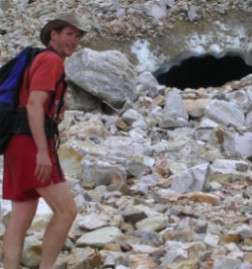 Man walking toward cave